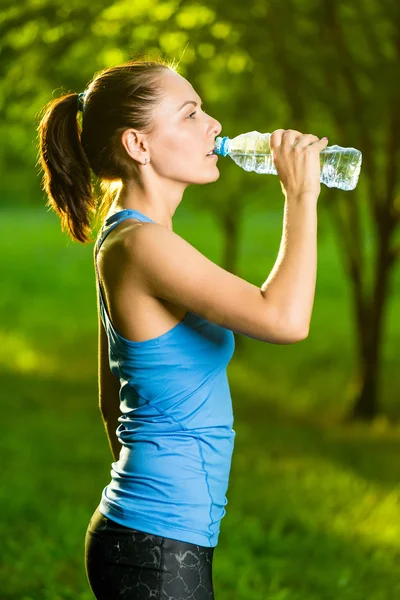 Young woman drinking water after fitness exercise — Stock Photo, Image