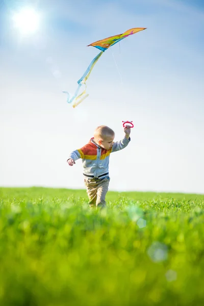 녹색 분야에 그의 연을 놀고 어린 소년. — 스톡 사진