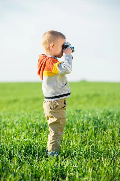 Little boy with an old camera shooting outdoor. — Stock Photo, Image