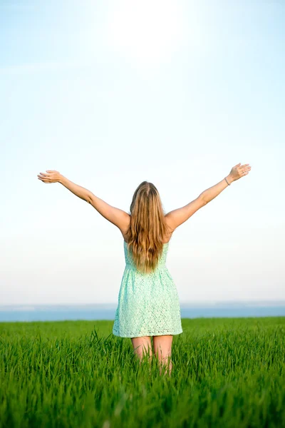 Felicidad mujer estancia al aire libre bajo la luz del sol de la puesta del sol — Foto de Stock