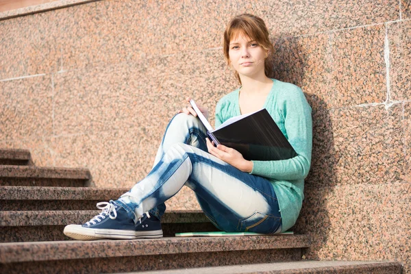 Mädchen sitzt auf Treppe und liest Notiz — Stockfoto