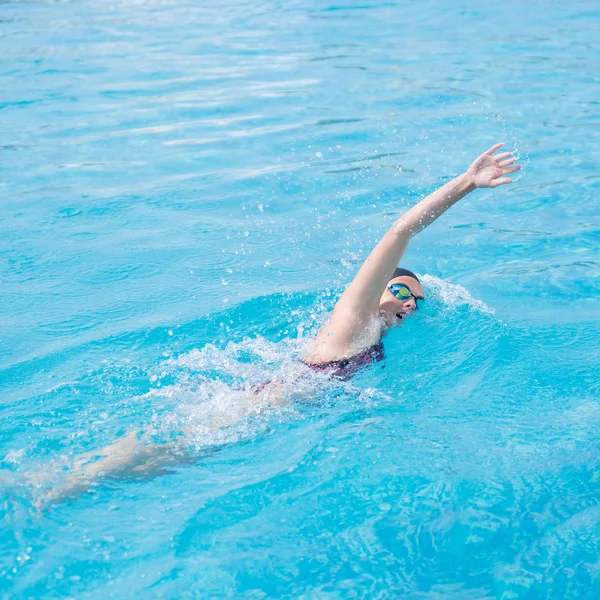 Woman in goggles swimming front crawl style — Stock Photo, Image