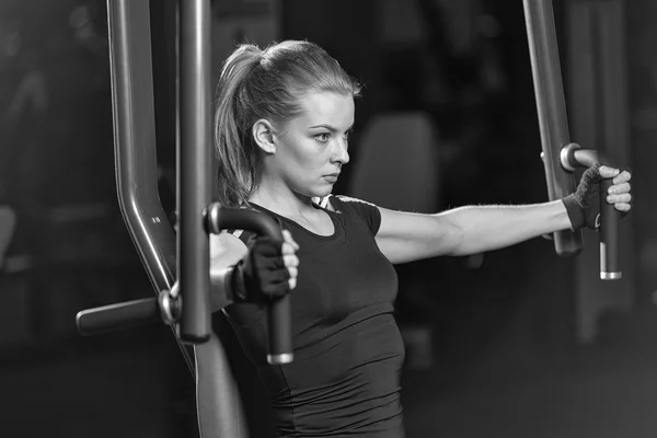 Kobieta na siłowni sport robi ćwiczenia ramion na maszynie — Zdjęcie stockowe