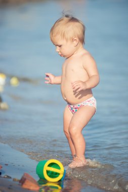 Şirin Bebek kumlu plajı ve deniz suyu oynarken.