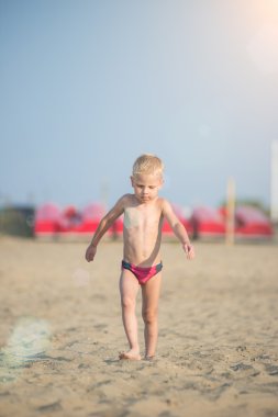 Kumsal deniz kenarında yürürken erkek sevimli bebek. Okyanus kıyısı.