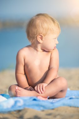 Şirin Bebek denize yakın kum plajındaki oyuncaklar ile oynama.