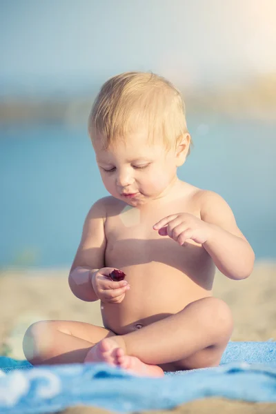 Симпатичный ребенок играет с игрушками на песчаном пляже у моря . — стоковое фото
