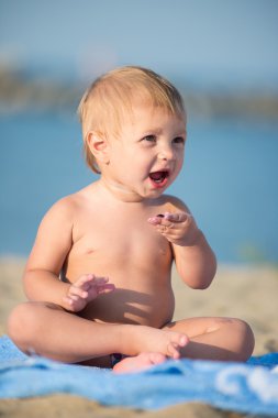 Şirin Bebek denize yakın kum plajındaki oyuncaklar ile oynama.