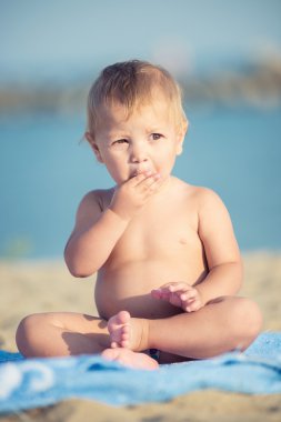 Şirin Bebek denize yakın kum plajındaki oyuncaklar ile oynama.