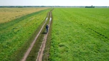 Anteni: yeşil ve sarı alan ile kırsal Road bisiklet üzerinde Bisiklete binme genç adam.