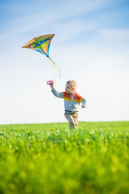 Genç çocuk onun uçurtma yeşil alan ile oynarken.