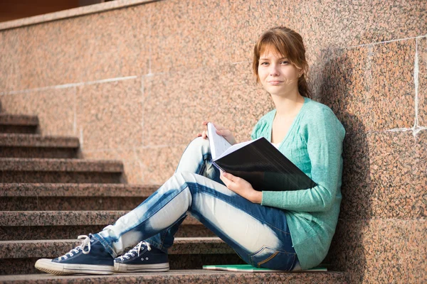 Mädchen sitzt auf Treppe und liest Notiz — Stockfoto