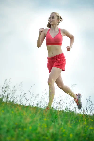 Молодая женщина, бегущая по сельской дороге летнего парка. Упражнения на открытом воздухе. J — стоковое фото