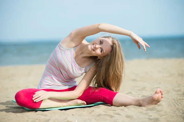 Ung dam praktisera yoga. Träning nära havet seglar utmed kusten. — Stockfoto