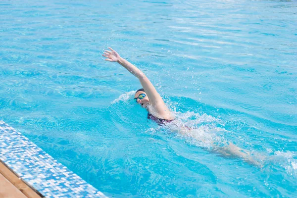 Frau in Schutzbrille schwimmt im Crawl-Stil — Stockfoto