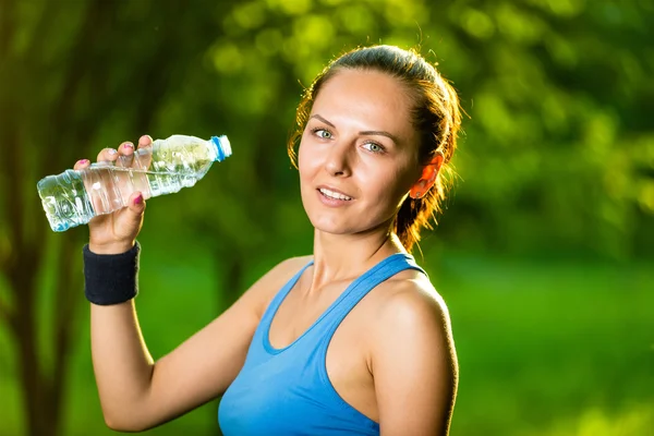 Νεαρή γυναίκα πόσιμο νερό μετά την άσκηση φυσικής κατάστασης — Φωτογραφία Αρχείου