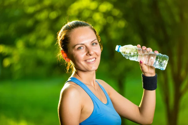 Young woman drinking water after fitness exercise — Stock Photo, Image