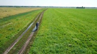 Anteni: yeşil ve sarı alan ile kırsal Road bisiklet üzerinde Bisiklete binme genç adam.