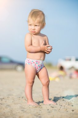 Şirin Bebek denize yakın kum plajındaki oyuncaklar ile oynama.