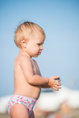 Şirin Bebek denize yakın kum plajındaki oyuncaklar ile oynama.