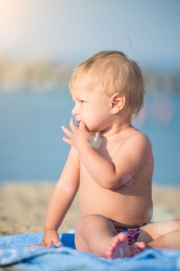 Şirin Bebek denize yakın kum plajındaki oyuncaklar ile oynama.