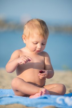 Şirin Bebek denize yakın kum plajındaki oyuncaklar ile oynama.