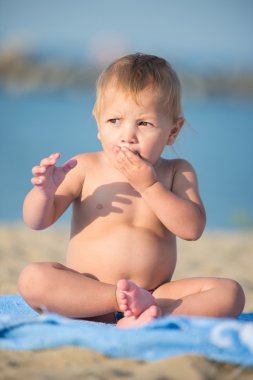 Şirin Bebek denize yakın kum plajındaki oyuncaklar ile oynama.