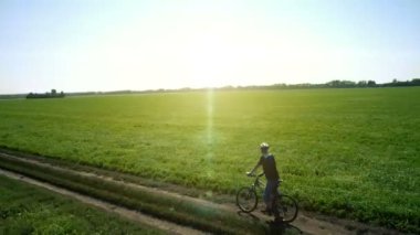 Anteni: yeşil ve sarı alan ile kırsal Road bisiklet üzerinde Bisiklete binme genç adam.
