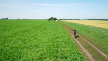 Anteni: yeşil ve sarı alan ile kırsal Road bisiklet üzerinde Bisiklete binme genç adam.