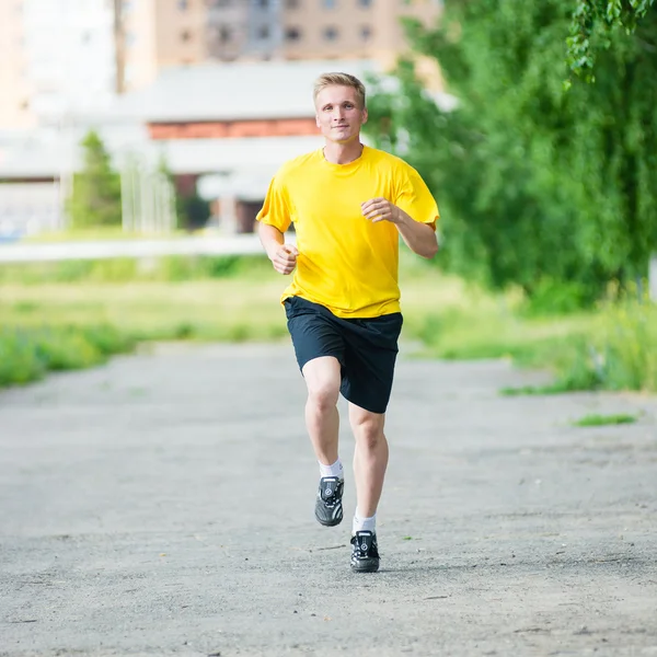 Homem desportivo a correr no parque urbano. Aptidão exterior . — Fotografia de Stock