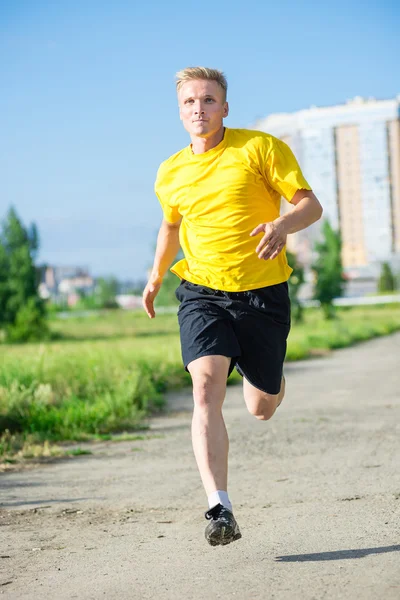 Sporty man jogging in city street park. Outdoor fitness. — Stock Photo, Image