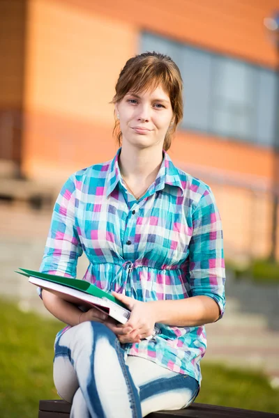Studentin mit Textbuch auf Bank. Sommer-Campus-Park. — Stockfoto
