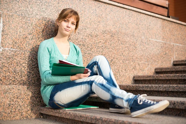 Girl sitting on stairs and reading note — Stock Photo, Image