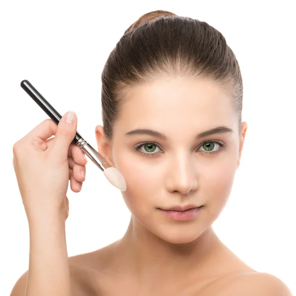 Ung brunett kvinna med rena ansikte. Flicka perfekt hud tillämpa kosmetiska borste. Isolerad på en vit. — Stockfoto