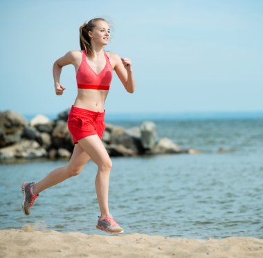 Güneşli yaz kum plajda çalışan genç bayan. Egzersiz. Jog