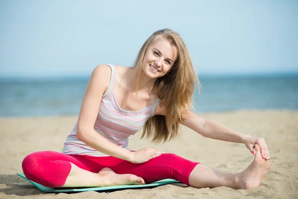 Młoda dama Praktykuje jogę. Trening w pobliżu wybrzeża Oceanu. — Zdjęcie stockowe