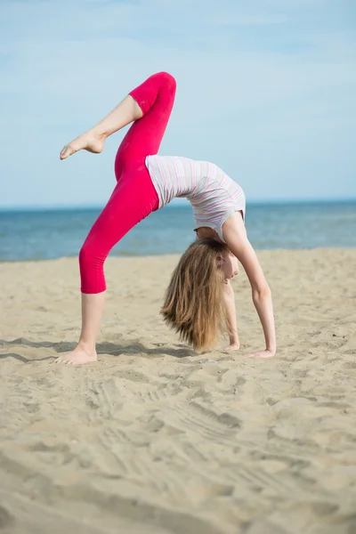 Jonge dame praktizerende yoga. Training in de buurt van de kust van de zee oceaan. — Stockfoto