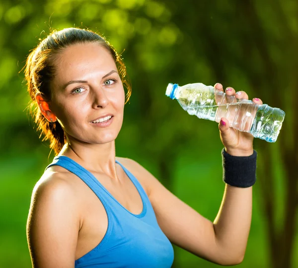 Mujer joven bebiendo agua después del ejercicio físico — Foto de Stock