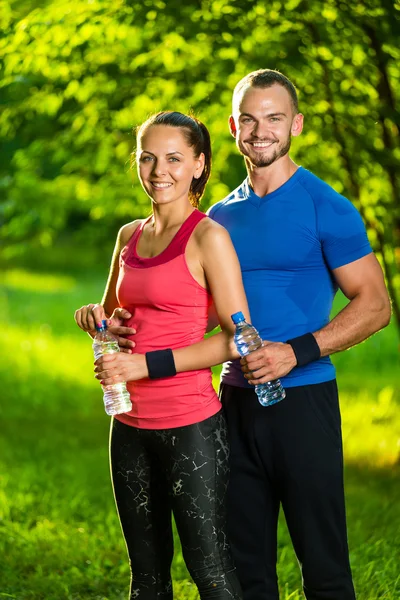 男人和女人的饮用水瓶后健身体育锻炼 — 图库照片