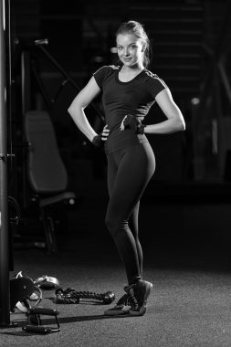 Bir makine üzerinde silah egzersizleri yapıyor spor salonunda kadın