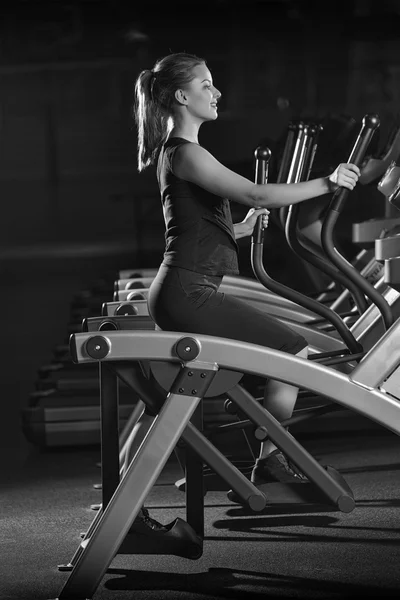 Mujer joven en el gimnasio haciendo ejercicio. Ejecutar en máquina . —  Fotos de Stock