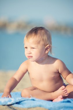 Şirin Bebek denize yakın kum plajındaki oyuncaklar ile oynama.