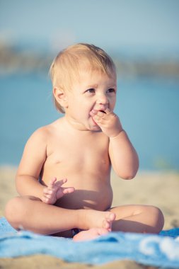 Şirin Bebek denize yakın kum plajındaki oyuncaklar ile oynama.