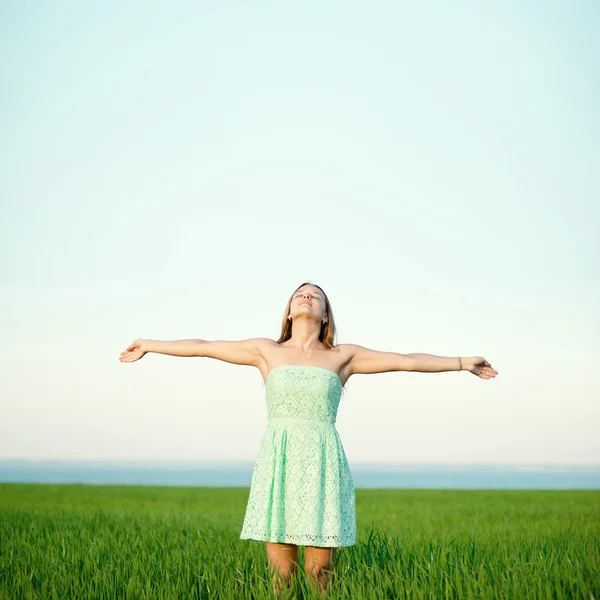 Felicidad mujer estancia al aire libre bajo la luz del sol de la puesta del sol — Foto de Stock