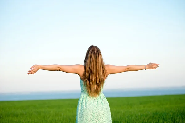 Felicidad mujer estancia al aire libre bajo la luz del sol de la puesta del sol — Foto de Stock