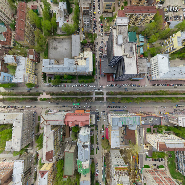 Aerial city view with crossroads and roads, houses, buildings, parks and parking lots, bridges. Copter shot. Panoramic image.