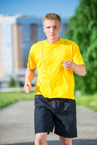 Sportieve man joggen in straat skyline van de stad. Buiten fitness. — Stockfoto