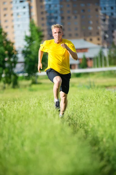 Sporty man jogging in city street park. Outdoor fitness. — Stock Photo, Image