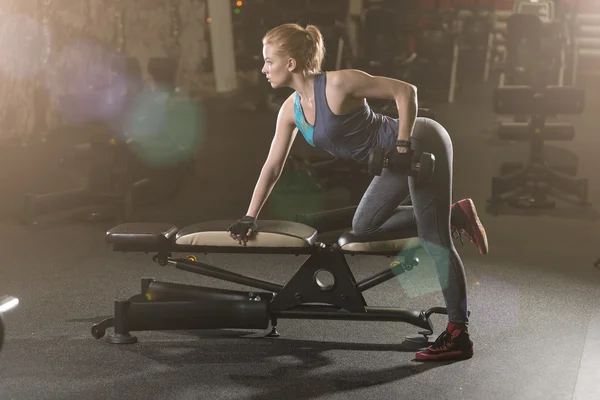 Young woman lifting the dumbbells — Stock Photo, Image