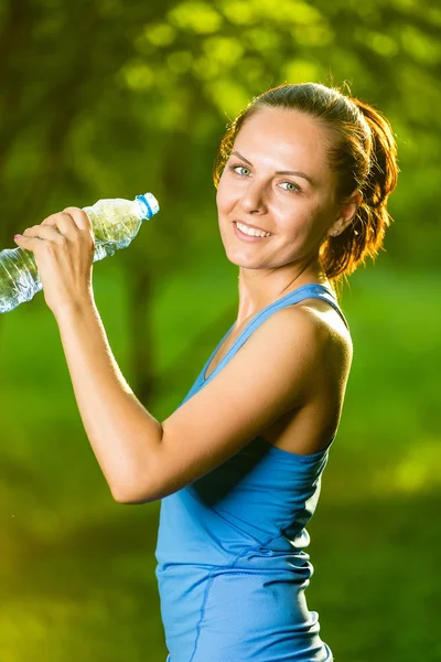 Mladá žena pitná voda po fitness cvičení — Stock fotografie